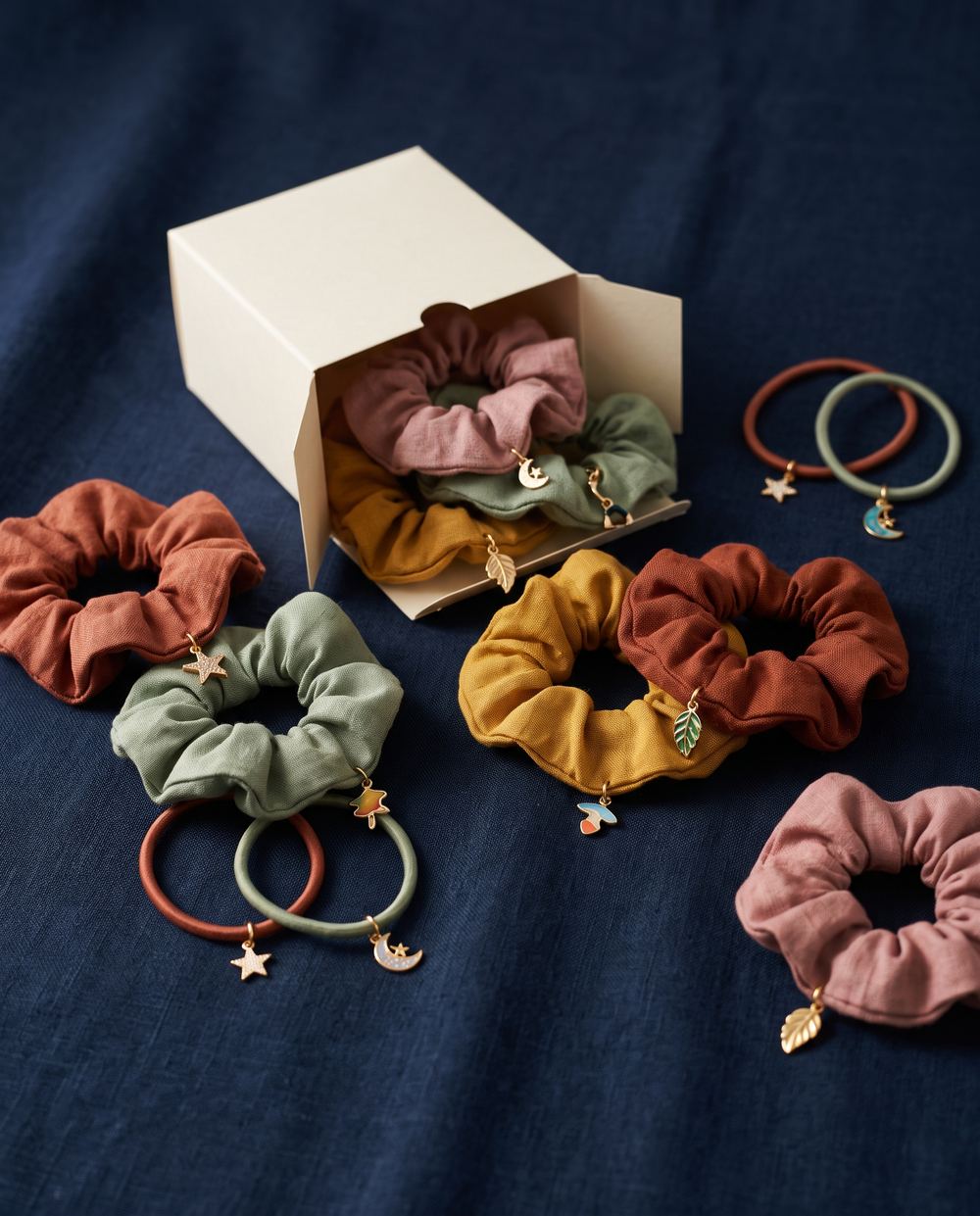 Fabric hair ties and scrunchies with small charms on navy linen